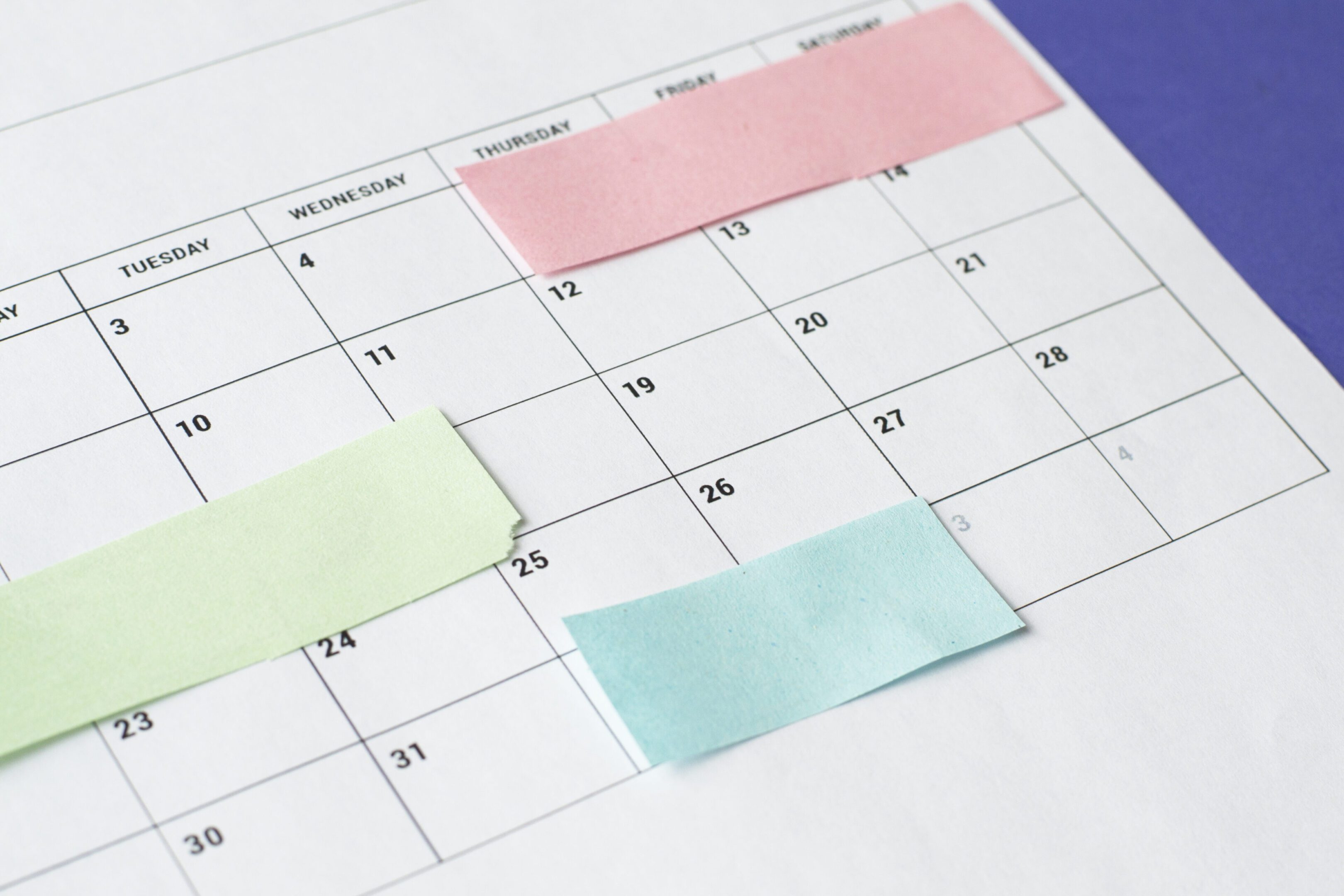 Calendar of the month and several colored adhesive notes to highlight the activities to be done. Copy space. Concept of time organization and achievement of objectives.